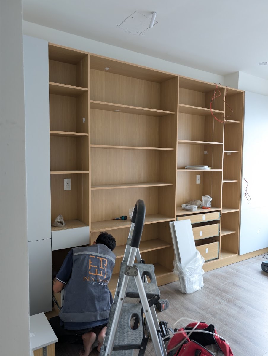 Thợ InEx lắp đặt hệ kệ gỗ âm tường trong căn hộ